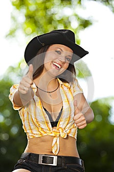 Laughing brunette woman posing thumbs up