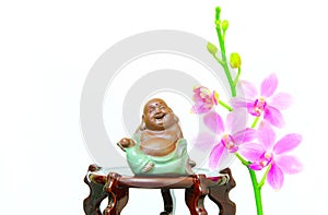 Laughing buddha figurine and pink orchid flowers