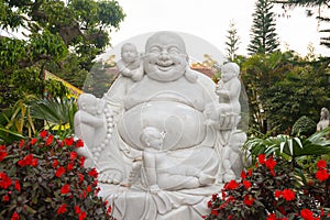 Laughing buddha with happy children, statue in Dalat, Vietnam