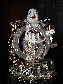 This is a laughing Buddha image at black background