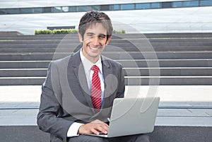 Laughing businessman with black hair and computer