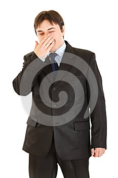 Laughing businessman closing his mouth by hand