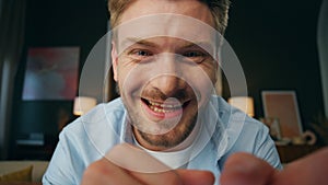 Laughing businessman videocalling at room web camera view. Man nodding head