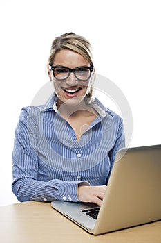 Laughing businesswoman working at her laptop