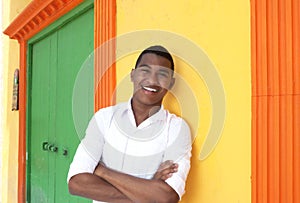 Laughing caribbean guy in front of a colorful house