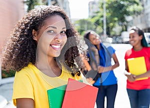 Laughing caribbean student in the city with friends