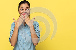 Laughing casual woman covering her mouth with both hands