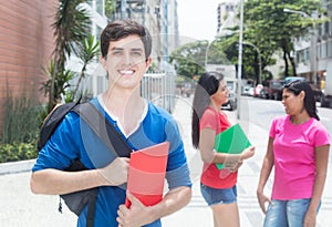 Laughing caucasian male student with friends