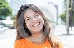 Laughing caucasian woman in a orange shirt in the city