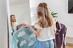 Laughing Child with Sweaters, Fun Wardrobe Choices. Morning preparation before school