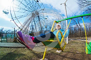 Laughing child on a swing in the spring park