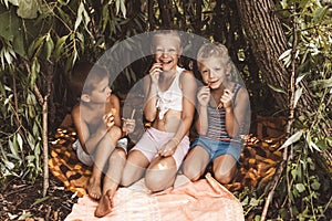 Laughing children play in a hut made of twigs and leaves. Wooden house in the village