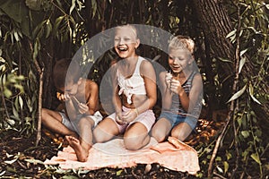 Laughing children play in a hut made of twigs and leaves. Wooden house in the village