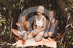 Laughing children play in a hut made of twigs and leaves. Wooden house in the village