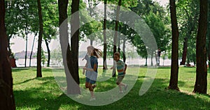 Laughing children running on sunny meadow. Happy kids play catch-up in park.