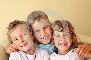 Laughing children three together in cosy room