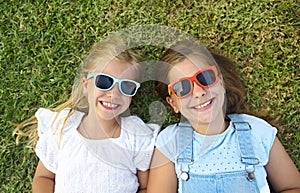 Laughing children wearing sunglasses relaxing during summer day
