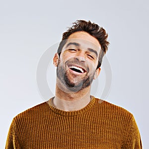 Laughing, comedy and portrait of happy man by white background. Smile, confident and face laugh of comic person