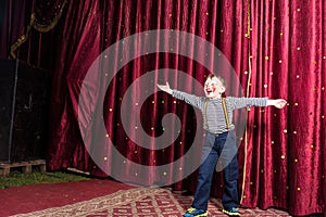 Laughing confident little boy on stage