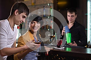 Laughing couple drinking at a pub counter