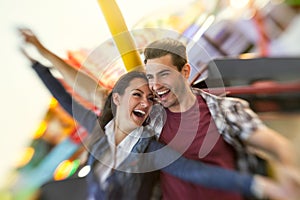 Laughing couple enjoy in riding ferris wheel