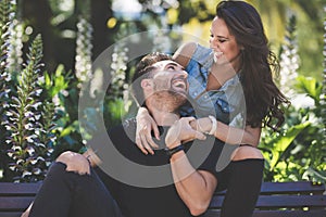 Laughing couple sitting together outside having fun