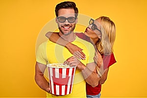 Laughing couple two friends guy girl in 3d glasses isolated on yellow background. People in cinema lifestyle concept. Watching