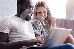 Laughing couple using laptop together