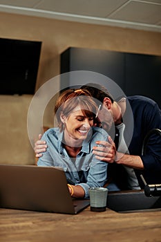 Laughing couple using a laptop together