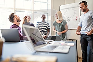 Laughing coworkers talking together after an office meeting