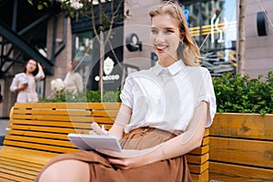 Laughing creative hipster lady drawing in sketchbook enjoying spending free time on hobby. Portrait of smiling young