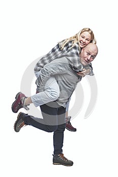 Laughing dad and adult daughter are fooling around. A young pretty blonde on the back of a bald man. Love and tenderness. Isolated