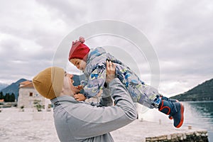 Laughing dad throws up a little girl on the island of Gospa od Skrpjela. Montenegro