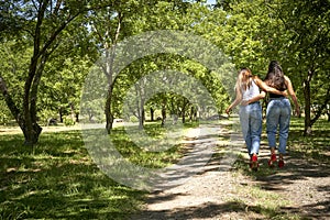 Laughing Diverse Girlfriends Holding Hands Strolling In Park