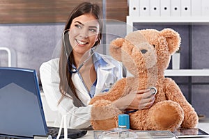 Laughing doctor with teddy bear