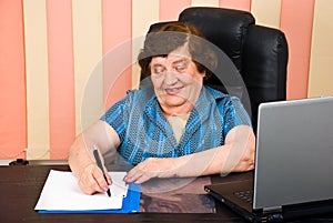 Laughing elder woman write on paper