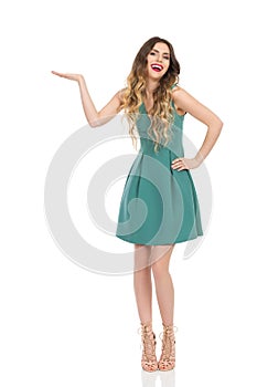 Laughing Elegant Woman In Mini Dress And High Heels Is Presenting