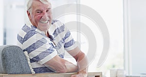 Laughing, face and senior man on a chair happy, good mood or chilling at home. Smile, portrait and elderly male person