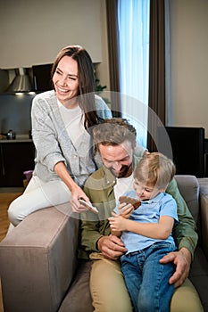 Laughing family enjoying Christmas time in hotel with tasty sweet gingerbread