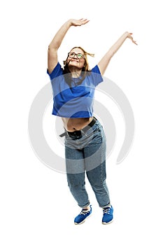 Laughing fat young girl in glasses and jeans emotionally jumps up. Energy and movement. Isolated on a white background. Vertical