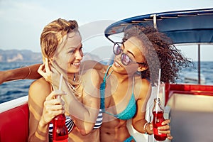 Laughing female friends having fun on a boat during vacation
