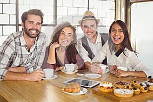 Laughing friends enjoying coffee and treats