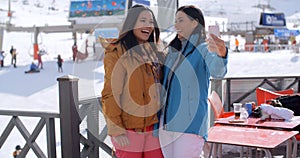 Laughing friends taking selfie at a ski resort