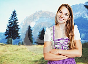 Laughing german woman in bavarian dirndl with rural landscape