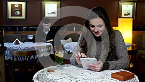 Laughing girl having tea in a coffee shop and boy