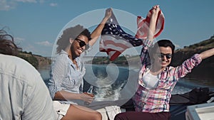 Laughing girls riding in a speedboat with flag