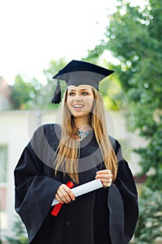 Laughing graduate with a diploma.