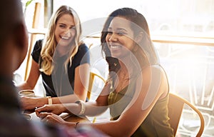 Laughing, group and friends drinking coffee in shop for talking, conversation or social gathering together in restaurant