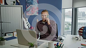 Laughing guy chatting cellphone in office close up. Startuper having phone call