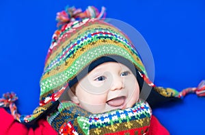Laughing happy baby wearing a funny knitted hat an